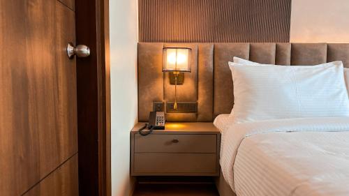 a bedroom with a bed and a lamp on a night stand at FHotels in Bengaluru
