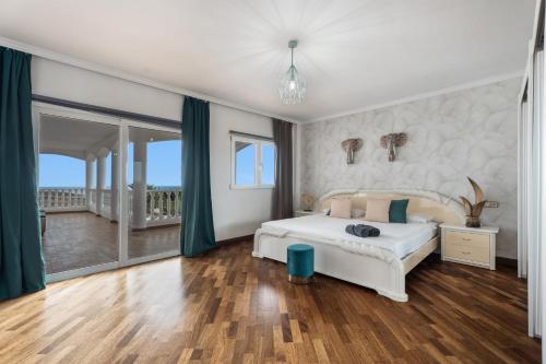 a bedroom with a white bed and green curtains at Villa Luxury el Mirador in Adeje
