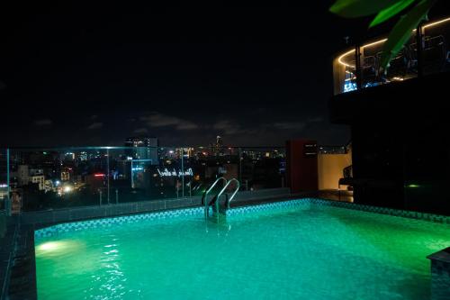 a swimming pool on top of a building at night at Champton Hanoi Hotel in Hanoi