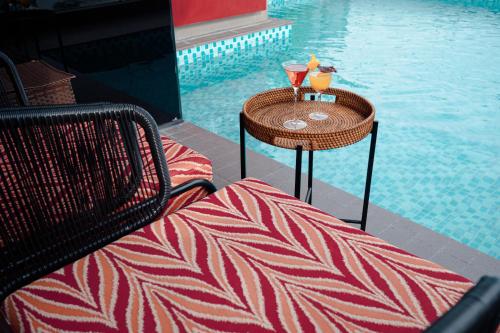 a table with two drinks on it next to a pool at Champton Hanoi Hotel in Hanoi