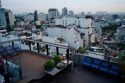 a balcony with chairs and a view of a city at Champton Hanoi Hotel in Hanoi