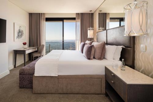 a bedroom with a large bed with a large window at The Leonardo in Johannesburg