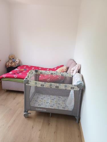 a baby crib in a room with a bed at Noclegi Jak u Babci in Nowe Miasto