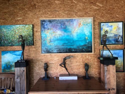 a table with sculptures on it in front of paintings at Domaine Bellevie BnB in Vex