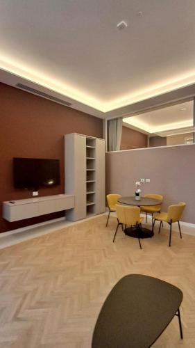 a living room with a table and chairs and a tv at Teatro Romano Exclusive Suites in Trieste