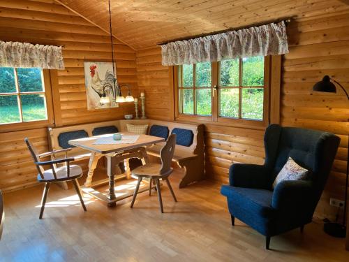 Un comedor con mesa y sillas y ventanas. en Landhaus An der Schafgasse, en Spittelstein