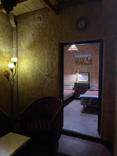 a mirror in a room with two beds and a chair at Riad Espace Asrir in Tiznit