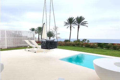 a villa with a swimming pool and a view of the ocean at Escape by Orchid in Batroûn