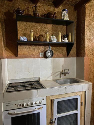 a kitchen with a stove and a sink at Riad Espace Asrir in Tiznit