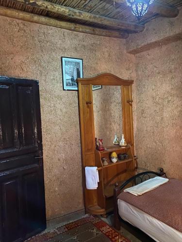 a bedroom with a bed and a wooden cabinet at Riad Espace Asrir in Tiznit