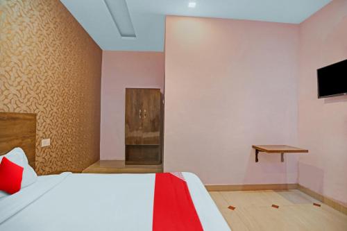 a bedroom with a bed and a tv on a wall at Hotel O Shri Nanadan Palace in Kānpur