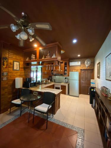 a large kitchen with a table and a refrigerator at Baan Laem Noi Villa's in Mae Nam