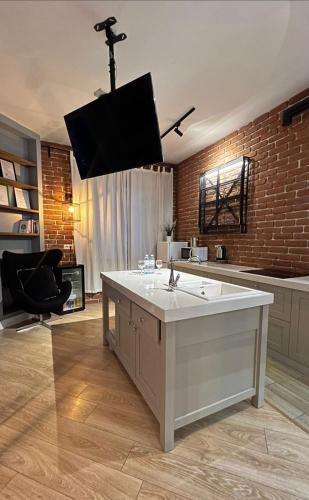 a kitchen with a sink and a tv hanging from the ceiling at Luxury apartment ЖК Вавилон Mountain View in Almaty