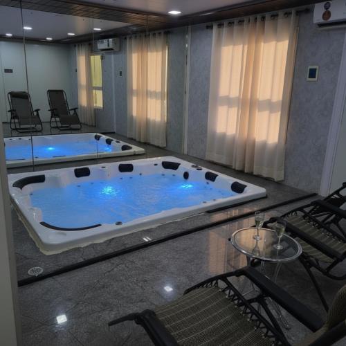 a large jacuzzi tub in a room with chairs at Kamal bliss resort in Karjat