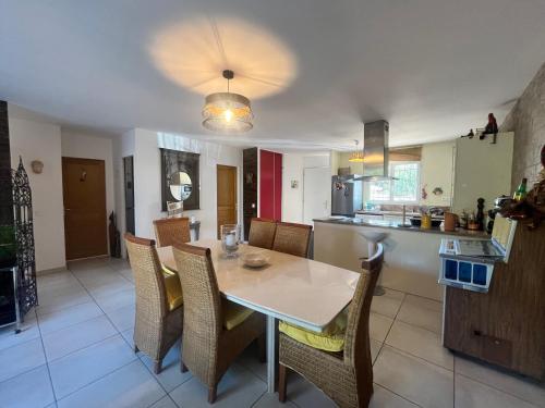 a kitchen and dining room with a table and chairs at FIORINO in Sainte-Lucie de Porto-Vecchio