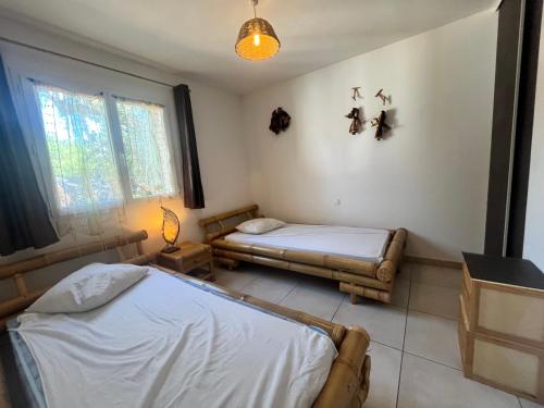a bedroom with two beds and a window at FIORINO in Sainte-Lucie de Porto-Vecchio
