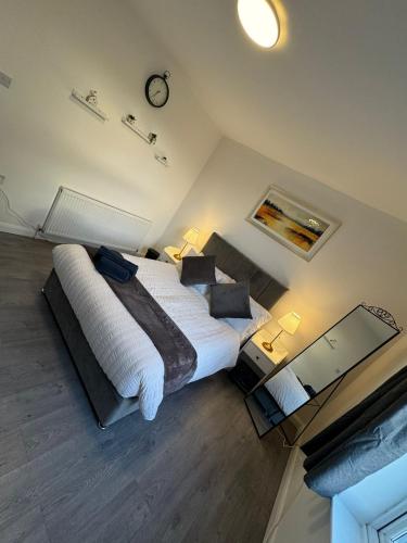 a bedroom with two beds and a clock on the wall at City Escape Stylish 4 bedroom house in Nottingham Sleep 9 in Nottingham