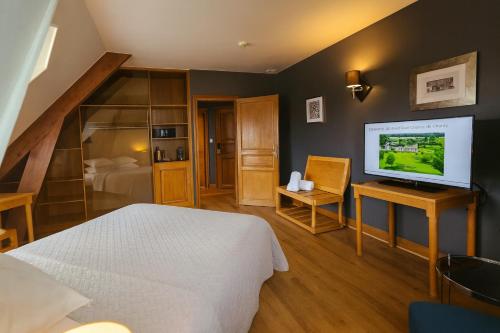 a bedroom with a bed and a flat screen tv at Hôtel Golf Château de Chailly in Chailly-sur-Armançon
