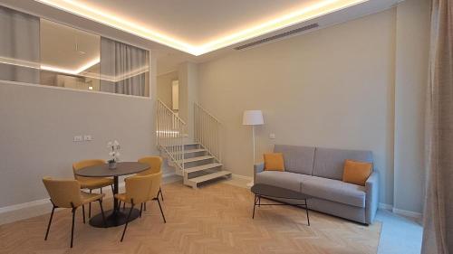 a living room with a couch and a table and chairs at Teatro Romano Exclusive Suites in Trieste