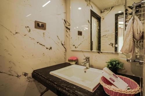 a bathroom with a sink and a mirror at The Rath Inns in Mandarmoni