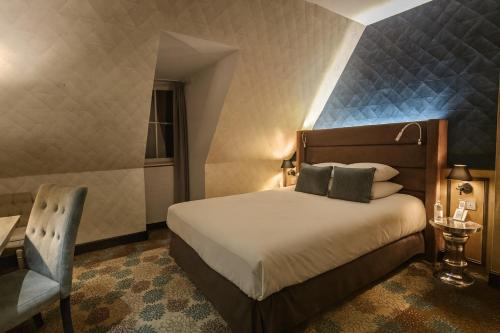 a hotel room with a bed and a chair at Hôtel Golf Château de Chailly in Chailly-sur-Armançon
