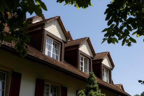 a building with three windows and a roof at Hotel Schlössli Garni - Free Parking in Ipsach