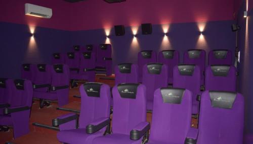 a room with purple chairs in a theater at Kamal bliss resort in Karjat