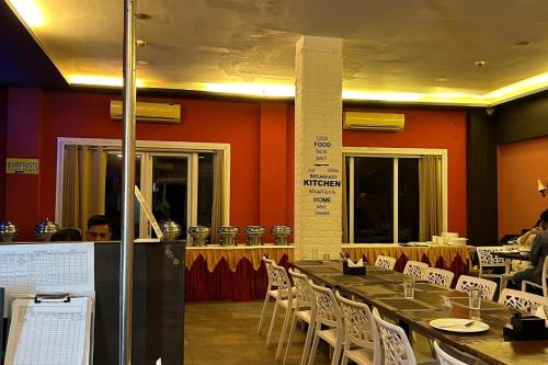 a dining room with a long table and white chairs at Kamal bliss resort in Karjat