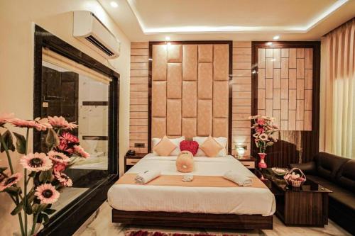 a bedroom with a large bed in a room with flowers at The Rath Inns in Mandarmoni