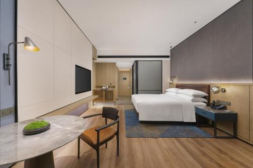 a hotel room with a bed and a table at Four Points by Sheraton Dalian Donggang in Dalian