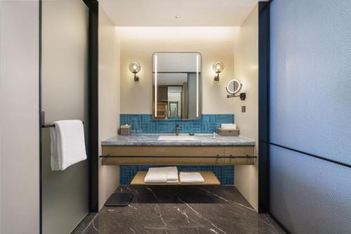 a bathroom with a sink and a mirror at Four Points by Sheraton Dalian Donggang in Dalian