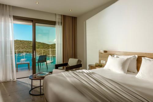 a hotel room with a bed and a view of the ocean at Sivota Deamaris Luxury Boutique Hotel in Sivota