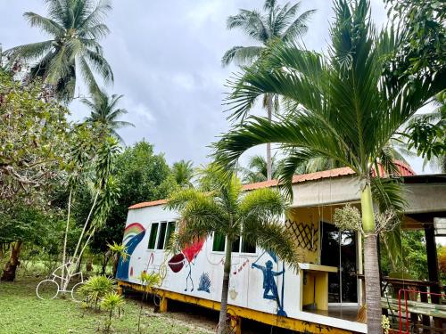 an old train car parked next to a house with palm trees at Wandee Resort Bankrut in Ban Krut