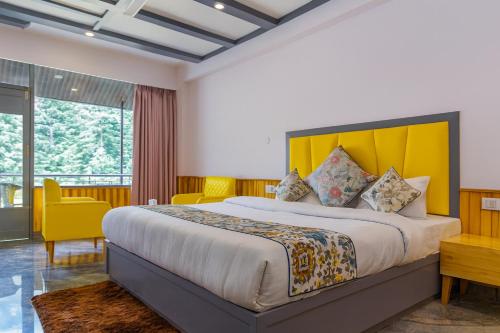 a bedroom with a large bed with a yellow headboard at Apple Flower Himalayan Heights - Luxury Stay with Mountain Views, Parking & Garden in Manāli