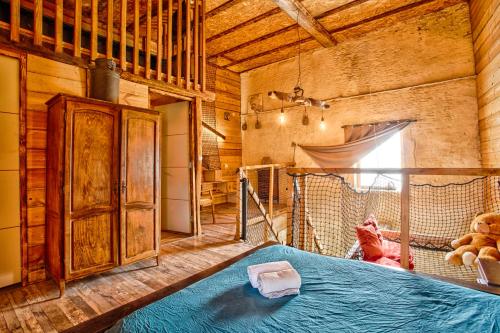 a bedroom with a blue bed in a room with a window at L'Apto - Gîtes à la ferme - Jardin avec plancha in Chicheboville