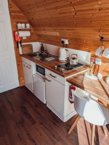 a kitchen with a stove and a sink and a table at Strathyre Camping Pods in Strathyre