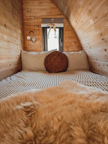 a bedroom with a bed in a wooden cabin at Strathyre Camping Pods in Strathyre