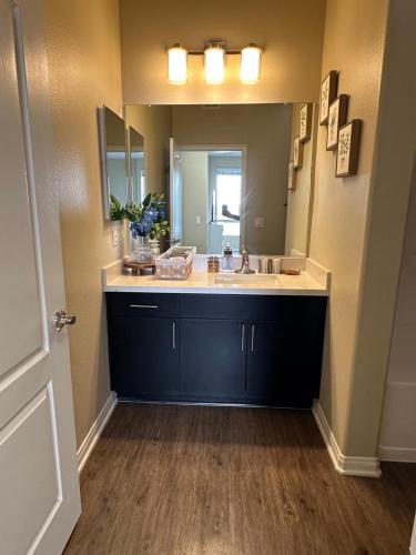 a bathroom with a sink and a large mirror at Spacious 2B 2B Pool View Loft Apartment in Marina Del Rey in Los Angeles