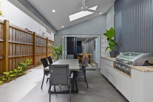 a patio with a table and chairs and a grill at Modern 3BR Glebe Home with Terrace & Garage for 8 in Sydney