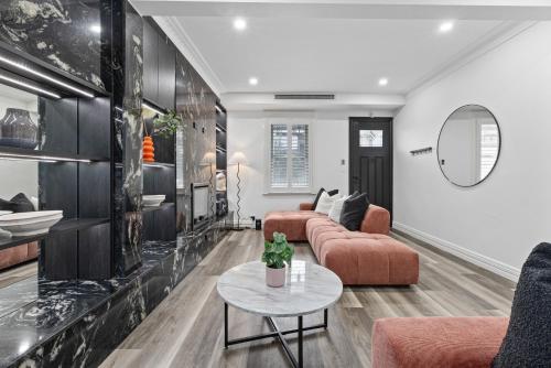 a living room with a couch and a table at Modern 3BR Glebe Home with Terrace & Garage for 8 in Sydney