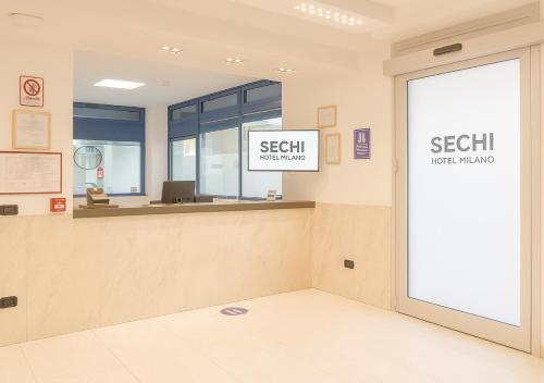 an office lobby with a reception desk and a window at Sechi Hotel Milano in Milan
