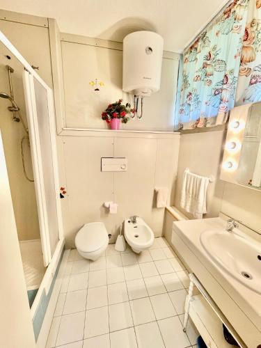 a small bathroom with a toilet and a sink at Appartamenti del Mare in Marina di Bibbona