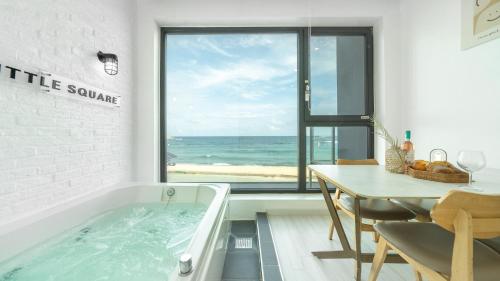 a bathroom with a tub with a table and a table and a table at Goseong Littlesquare Oceanview Pension in Goseong