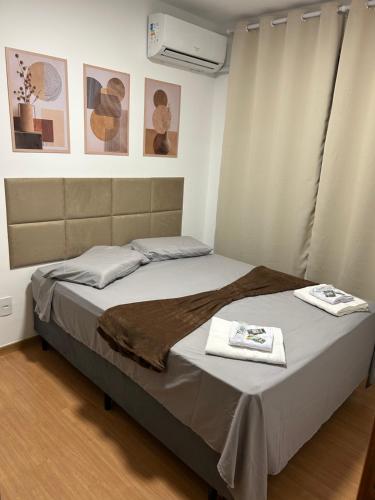 a bedroom with a bed with two towels on it at Apartamento completo, lindo e confortável em Duque de Caxias RJ in Duque de Caxias