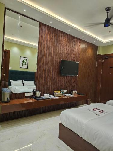 a hotel room with two beds and a large mirror at Hotel Crystal Sarovar in Mirzāpur