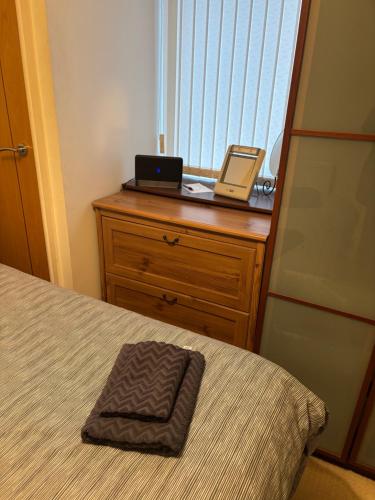 a bedroom with a bed and a laptop on a dresser at Thistle Tide 13 Nelson Street Largs KA308LN 1st Floor in Largs