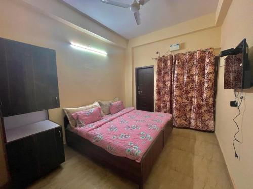 Un pequeño dormitorio con una cama y un televisor. en Entire villa near Medanta Hospital, en Gurgaon