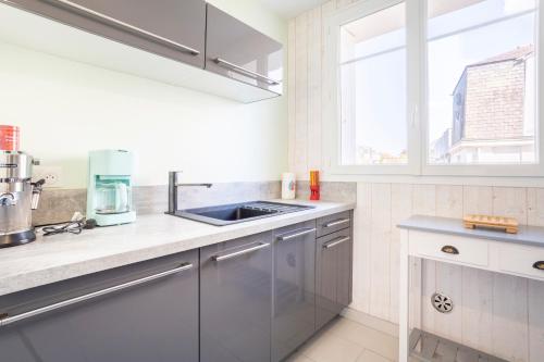 a kitchen with stainless steel appliances and a window at Appt 300m de la plage vue sur mer in Audierne
