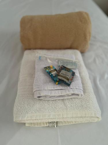 a pile of towels sitting on top of a bed at Apartamento completo, lindo e confortável em Duque de Caxias RJ in Duque de Caxias