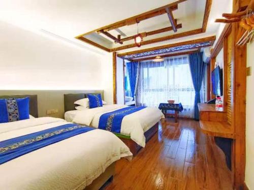 Una habitación de hotel con dos camas y un televisor. en Wuling Spring Inn, Yongding District, Zhangjiajie City, 